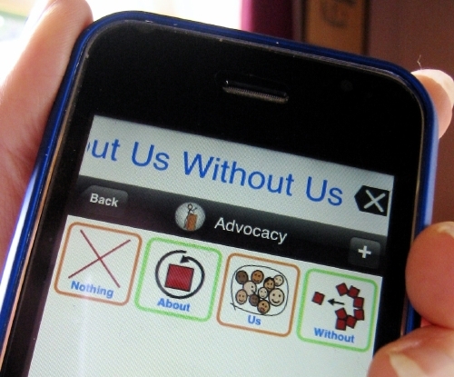 top half of iphone running proloquo2go application showing custom items nothing, about, us, without, and the text to speak at the top \"nothing about us without us\"