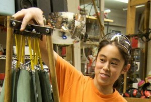 Amy Qian holds up disassembled early prototype of the SolSource 3-in-1 in MITERS.