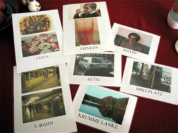 photographs of food and dinner table, subway, drinking and tomato juice, car, lake, a man, and a swing set, labeled respectively: essen, u-bahn, trinken, auto, krumme lanke, david, spielplatz