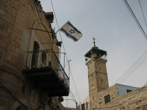 Israeli flag flies beside a Palestinian mosque in Hebron, Daniel J Gerstle.