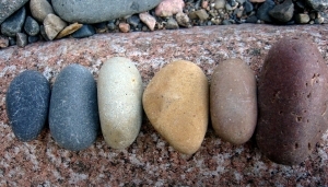 Arrangement by Dora line of 6 egg shaped stones: from left to right, violet, blue, green, yellow, orange, red