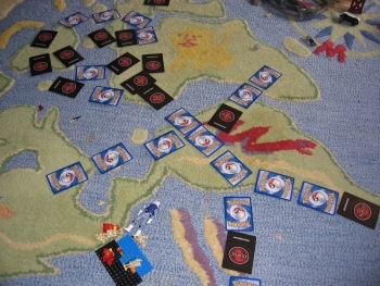 pokyman cards arranged in swirly shapes on a blue carpet that has a felt map of the the world sewn onto it