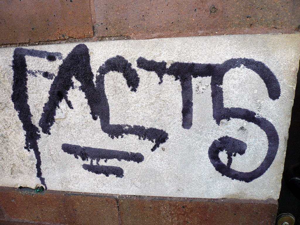 black grafiti on a brick wall reads 