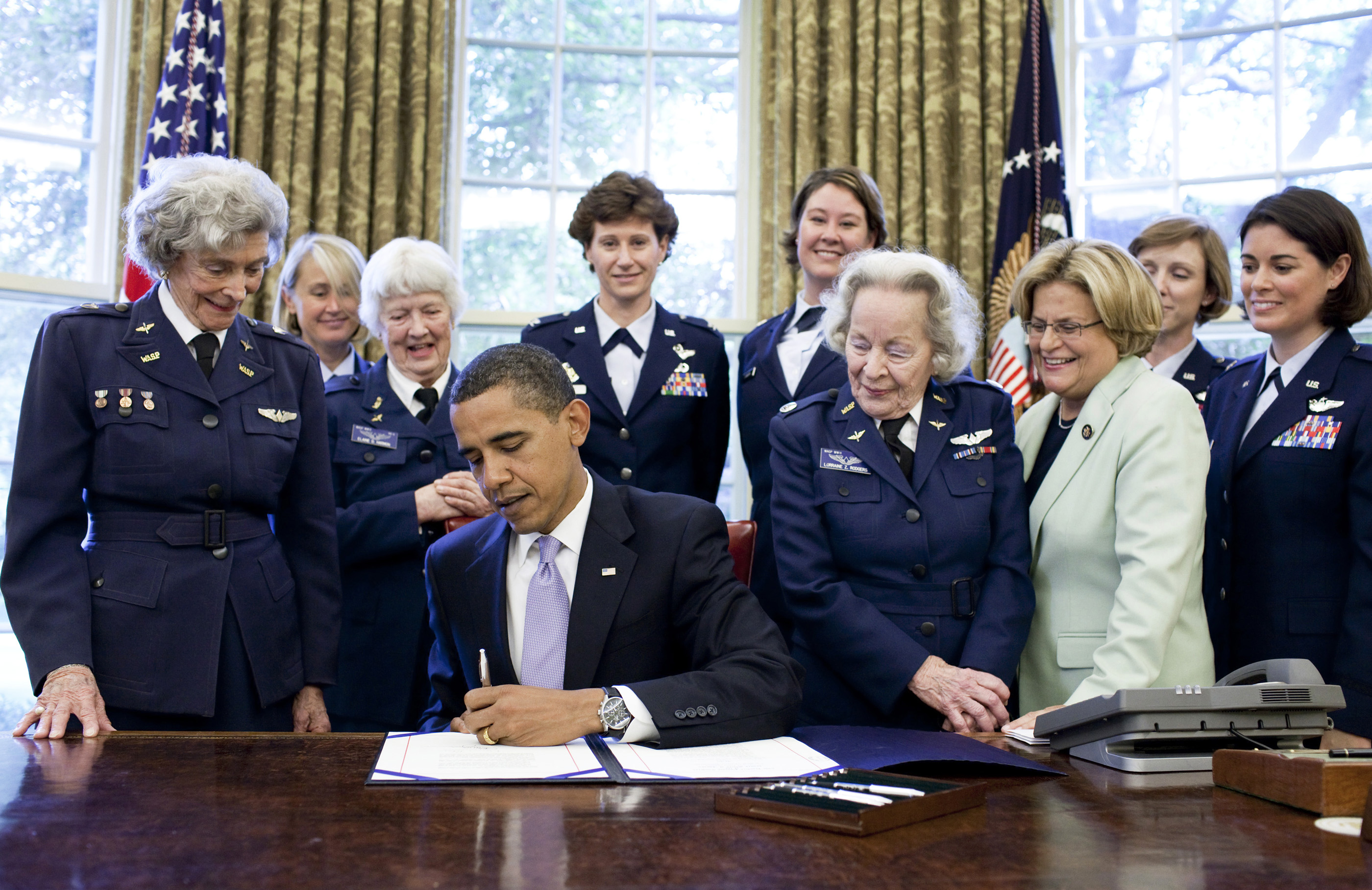 President Barack Obama signs S.614 in the Oval Office July 1 at the White House. The bill awards a Congressional Gold Medal to Women Airforce Service Pilots. The WASP program was established during World War II, and from 1942 to 1943, more than 1,000 women joined, flying 60 million miles of noncombat military missions. Of the women who received their wings as Women Airforce Service Pilots, approximately 300 are living today. The women in this photo are Rep. Ileana Ros-Lehtinen, Women’s Airforce Service Pilots Elaine Danforth Harmon, Lorraine H. Rodgers and Bernice Falk Haydu, and active duty USAF pilots Colonel Dawn Dunlop, Colonel Bobbi Doorenbos, Lieutenant Colonel Wendy Wasik, Major Kara Sandifur and Major Nicole Malachowski (former Thunderbird pilot).