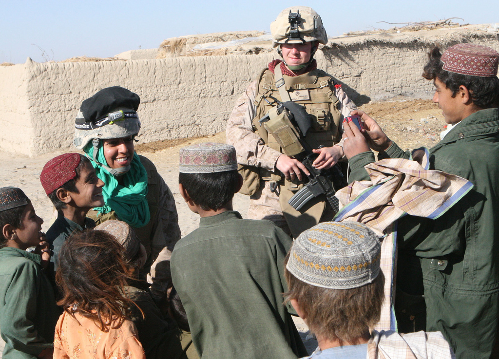 2nd Lt. Carly E. Towers, right, the officer in charge of the female engagement team, 2nd Battalion, 2nd Marine Regiment, and Sahima Sheren, or Sam, an interpreter with the FET team, interact with local kids during a patrol through Tajik Khar in Garmsir, Afghanistan, Dec. 18. With Easy Company, 2/2, and local Afghan National Army providing security, the FET moved from compound to compound, hoping to speak to the females to discuss what medical care and humanitarian assistance was needed for them.