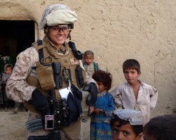 Cpl. Monica Boucher, a field radio operator with Combat Logistics Battalion 6, Marine Expeditionary Brigade-Afghanistan, mingles with a group of Afghan children during her first Female Engagement Team mission in Helmand province Feb. 26. Boucher spent approximately one week aboard Combat Outpost Shur, where she assisted the Marines of Fox Company, 2nd Battalion, 2nd Marine Regiment by making friendly contact with female residents. (Photo by Lance Cpl. Yahaira Cosme)