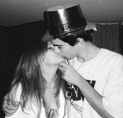 Black and white photo of two teenagers kissing.