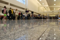 A view from the floor of a line of people standing in a line at an airport.