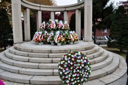 A white marble memorial adorned with various flower arrangements.