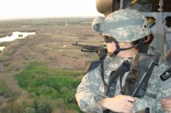 Aerial photo of a woman soldier holding a weapon flying over Iraq.
